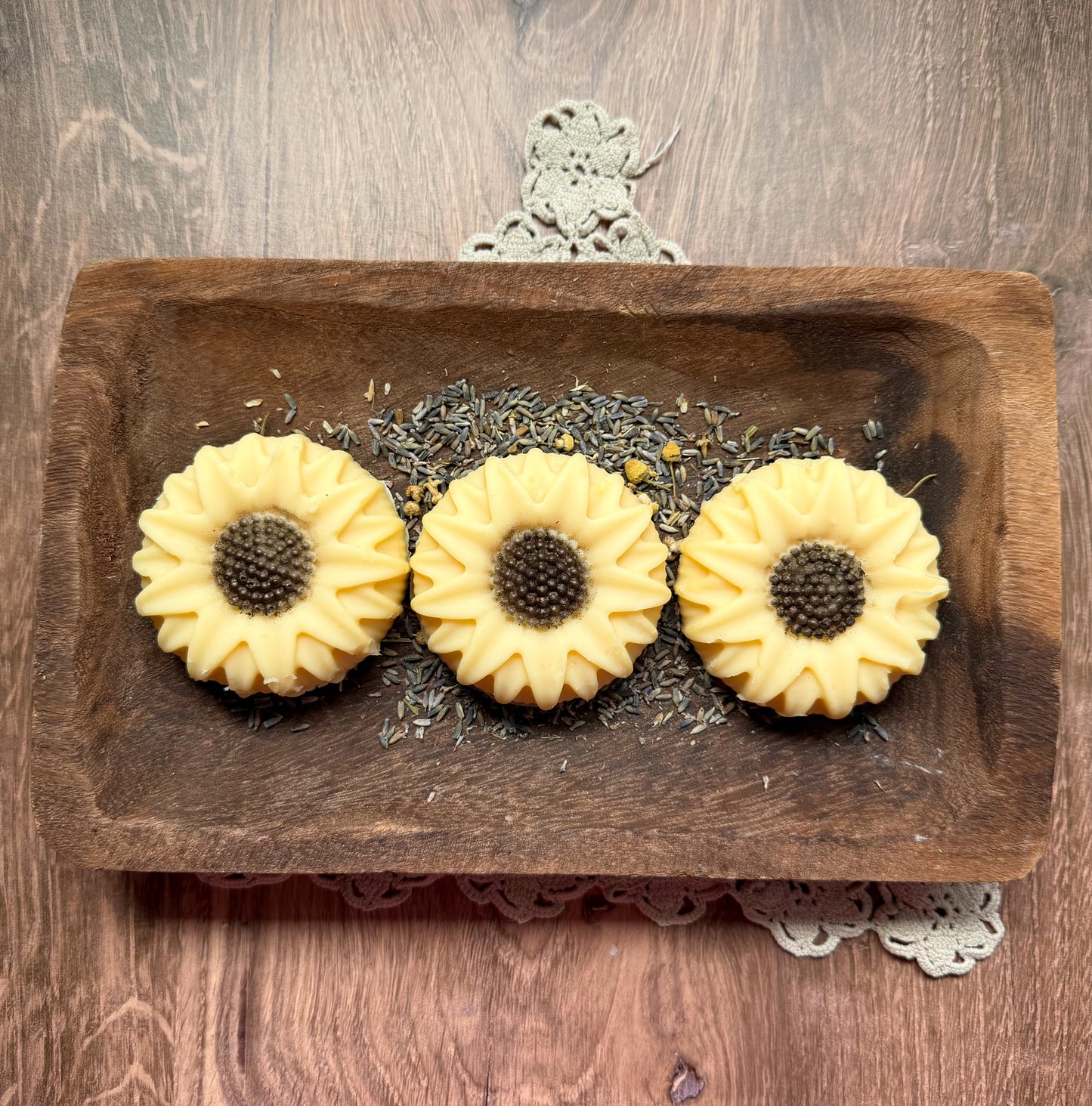 Sunflower Goat Milk Soap Gift Set by Lil Daisy Soaps on a wood slice, adorned with dried lavender.
