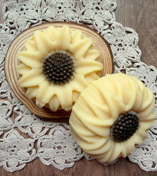 The Sunflower Goat Milk Soap Gift Set by Lil Daisy Soaps sits atop a wood slice, perfect for gifting.