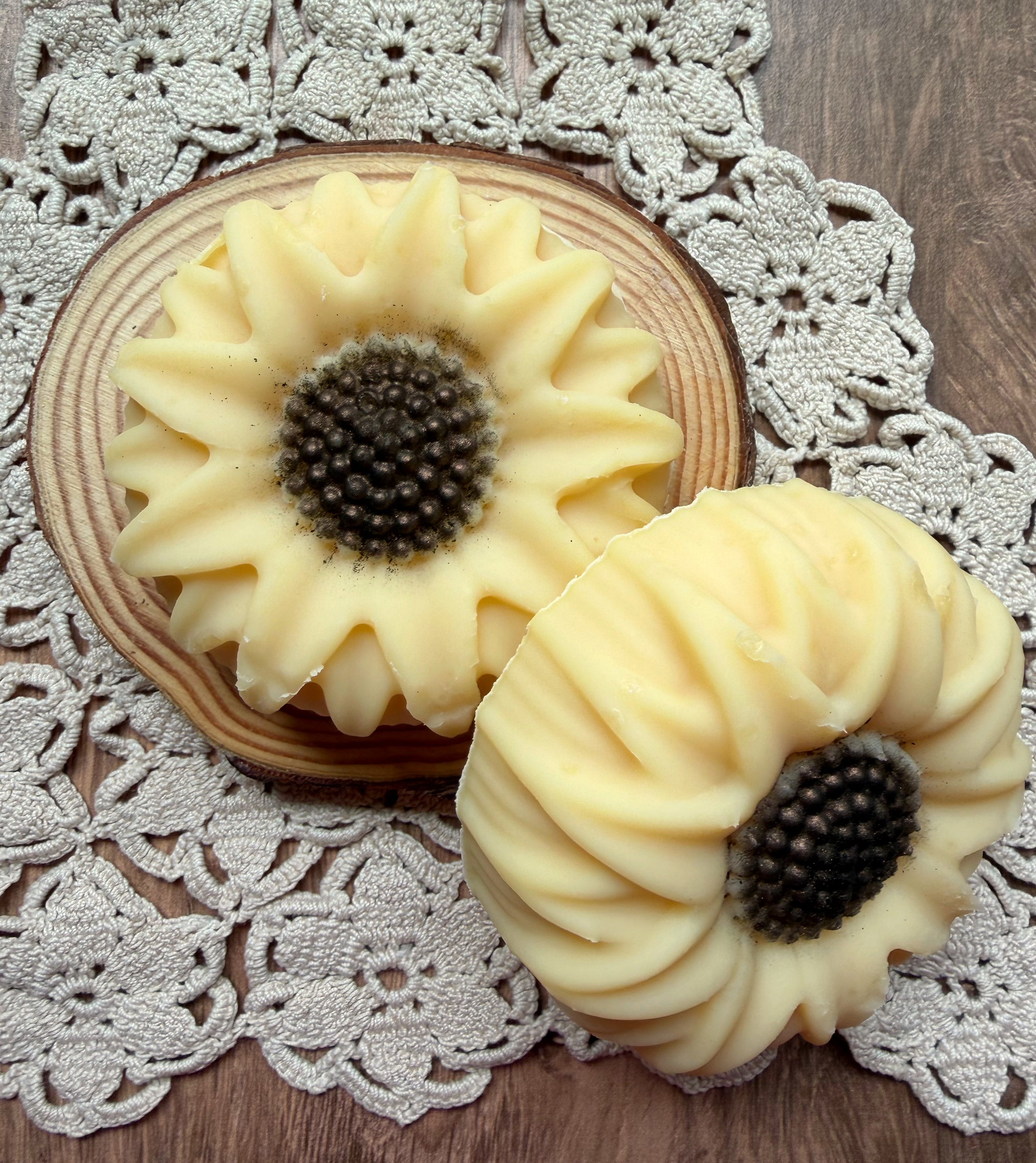 The Sunflower Goat Milk Soap Gift Set by Lil Daisy Soaps sits atop a wood slice, perfect for gifting.