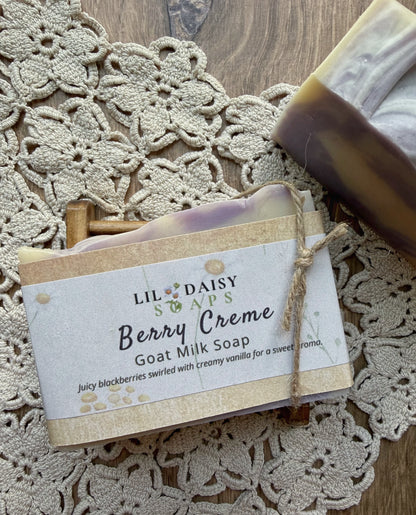 Lil Daisy Soaps Berry Creme Goat Milk Bar rests on a wooden dish atop a crocheted doily.