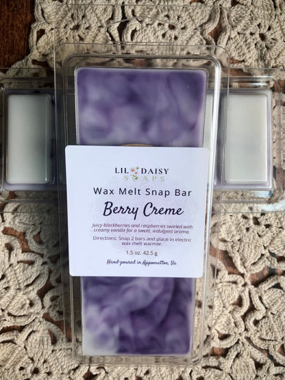 Purple Berry Creme wax melt snap bar in plastic packaging, placed on a crocheted beige tablecloth.