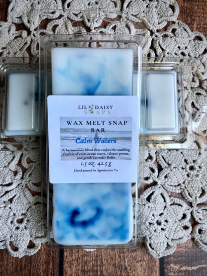 A Lil Daisy Soaps Calm Waters Wax Melt-Long Lasting Snap Bar with blue & white swirls rests on lace.
