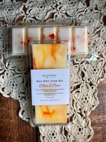 Two Lil Daisy Soaps Citrus & Clove Snap Bar Wax Melts on a crochet doily—ideal for cozy home fragrance.