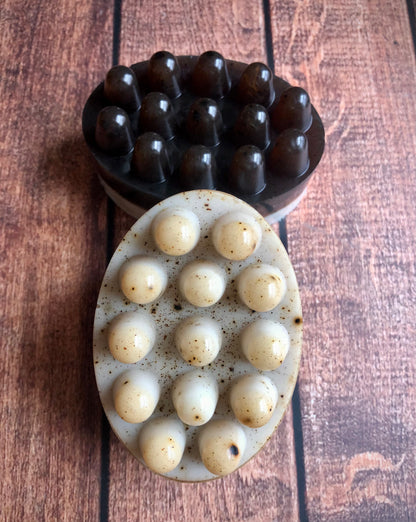 Lil Daisy Soaps Coffee & Cream Massage Soap Bars, dark brown and white with specks, rest on a wood surface.