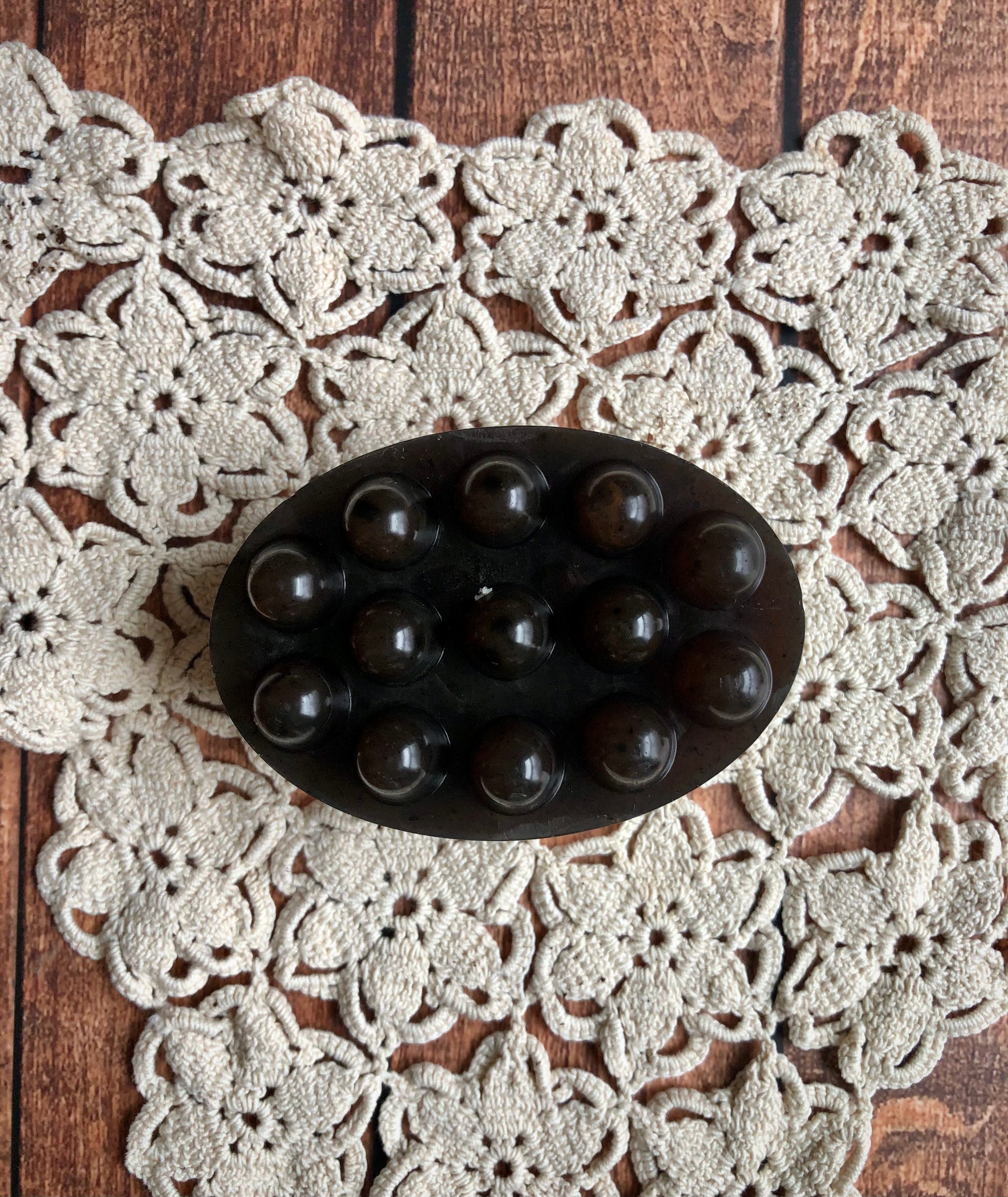 Lil Daisy Soaps Coffee & Cream Massage Bar with bumps sits on a crocheted doily on wood.