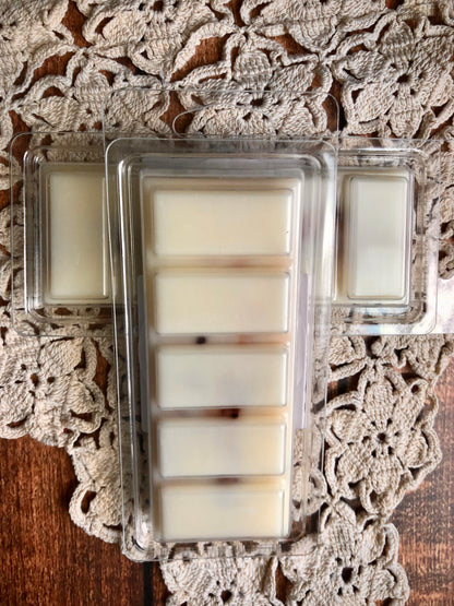 Three Lil Daisy Soaps Cup of Comfort Wax Melt Snap Bars on a lace doily, arranged in a T shape.