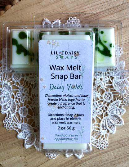 The Daisy Fields Wax Melt-Long Lasting Snap Bar by Lil Daisy Soaps on a lace doily and wooden surface.