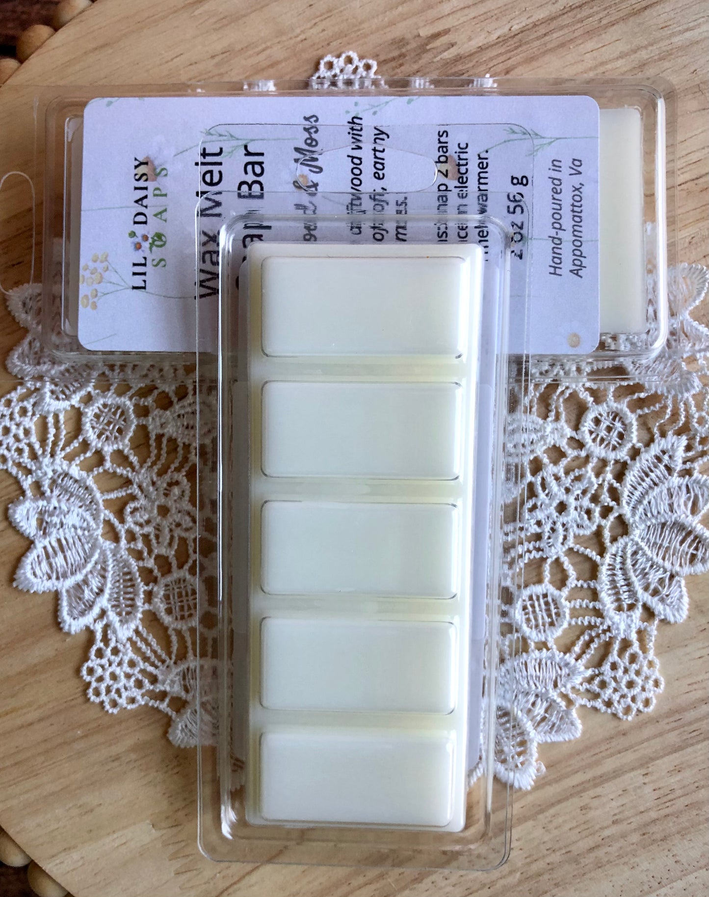 Six Driftwood & Moss Wax Melt Snap Bars by Lil Daisy Soaps displayed on a crocheted doily on wood.