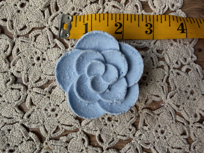 Lil Daisy Soaps Essential Oil Shower Steamer, blue flower shape, 3″ wide, shown on lace.