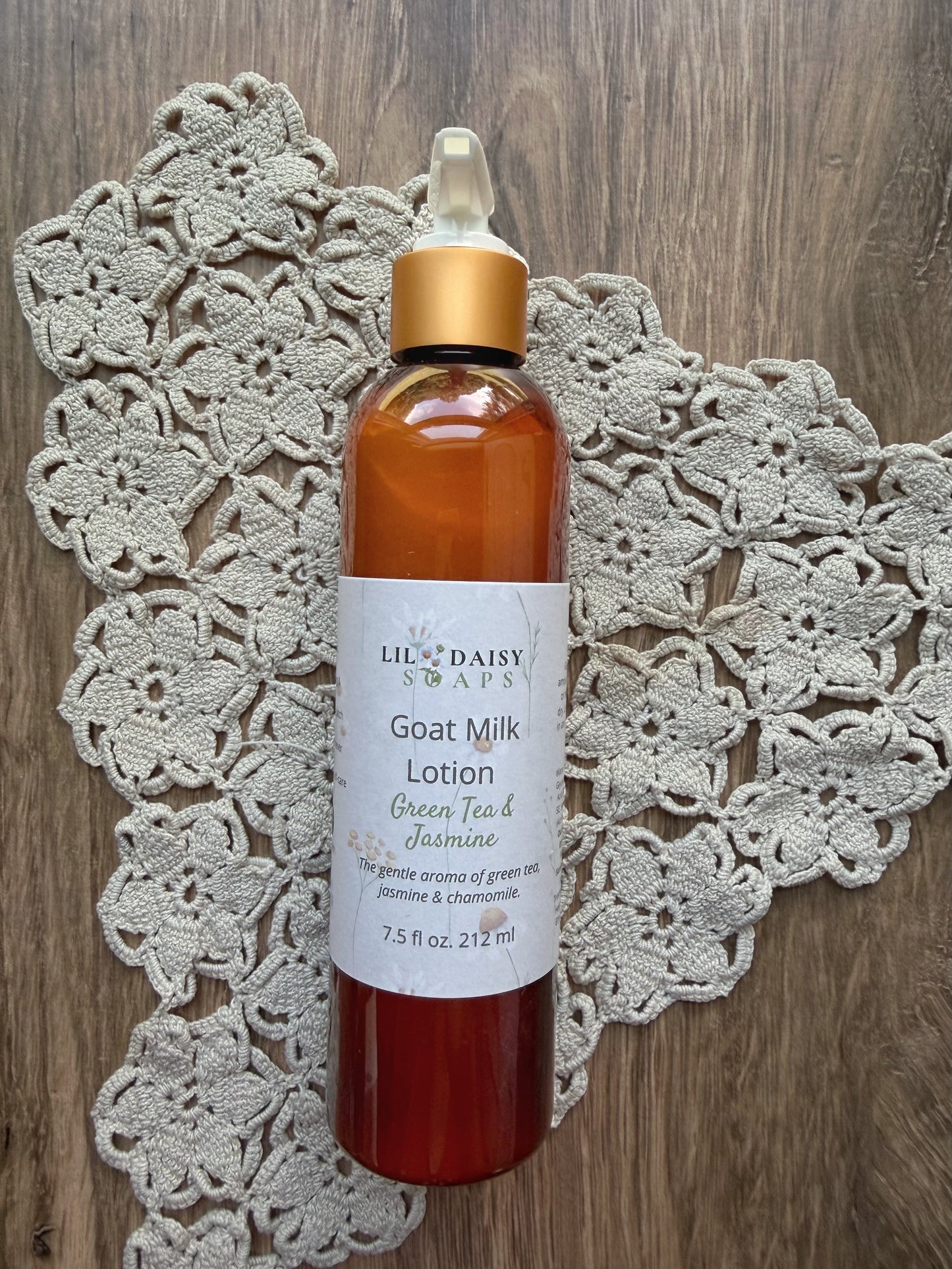 Lil Daisy Soaps Goat Milk Lotion sits on a crocheted doily on wood; a lightweight daily moisturizer.