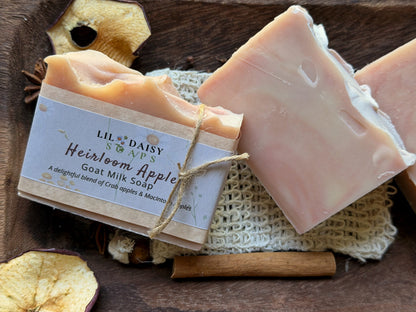 Lil Daisy Soaps’ Heirloom Apple Goat Milk Soap with creamy goat milk & apple slices on a wooden tray.