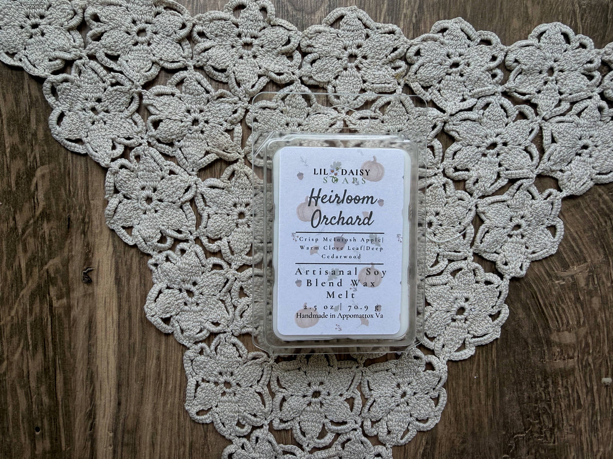 Heirloom Orchard soy wax melt by Lil Daisy Soaps, Macintosh apple scent, sits on lace atop wood.