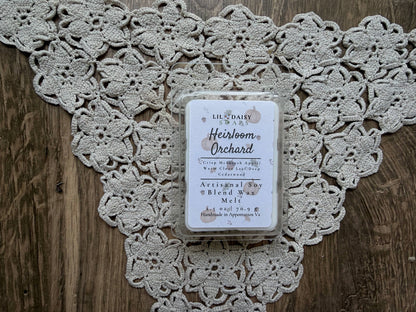 Heirloom Orchard soy wax melt by Lil Daisy Soaps, Macintosh apple scent, sits on lace atop wood.