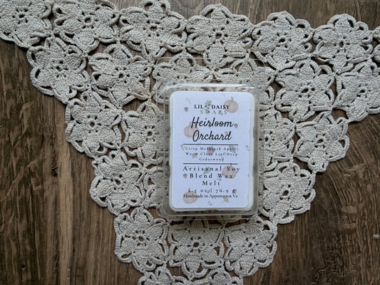 Heirloom Orchard soy wax melt by Lil Daisy Soaps, Macintosh apple scent, sits on lace atop wood.