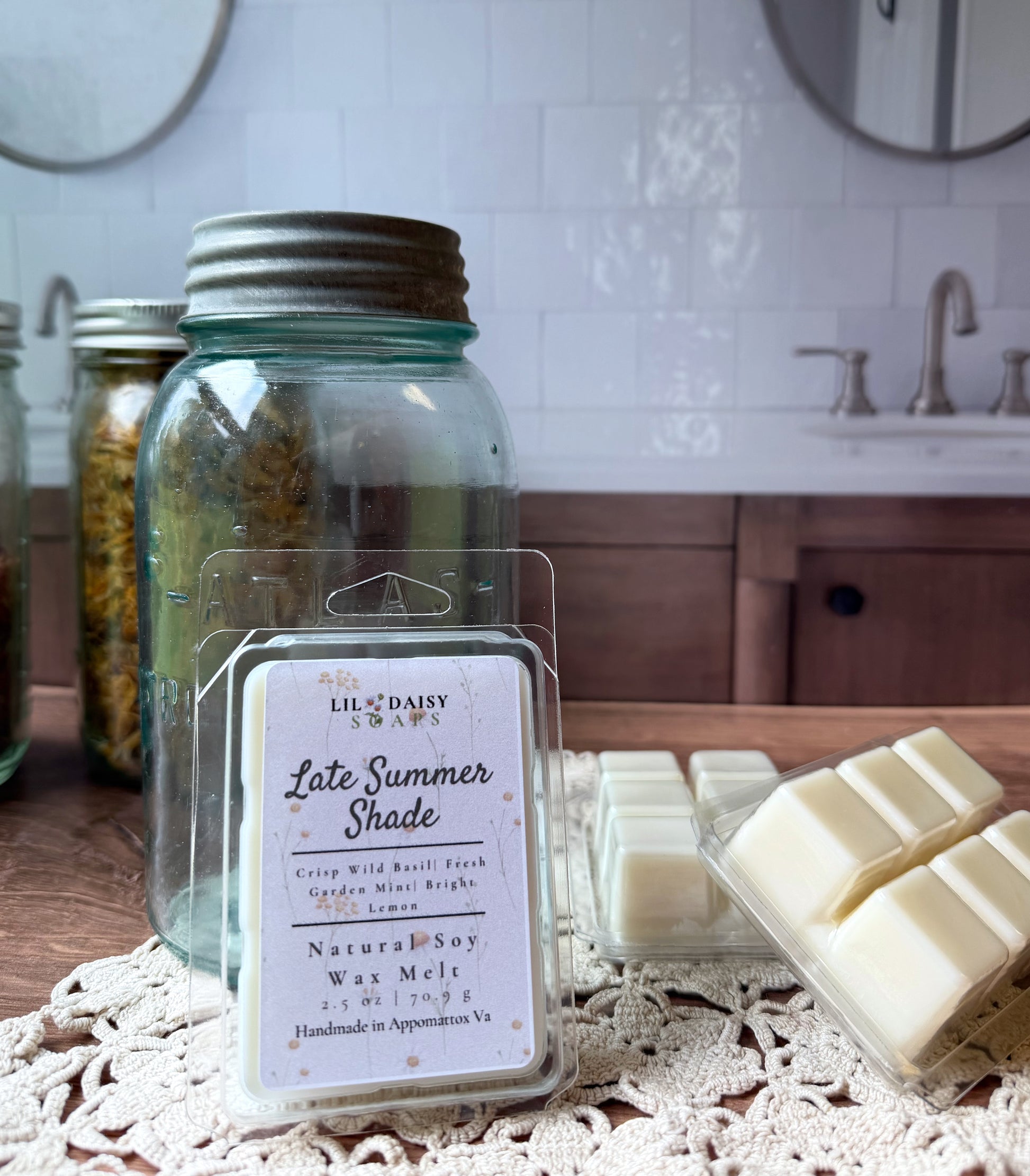 Late Summer Shade Soy Wax Melts by Lil Daisy Soaps rest on lace near mason jars and a kitchen sink.