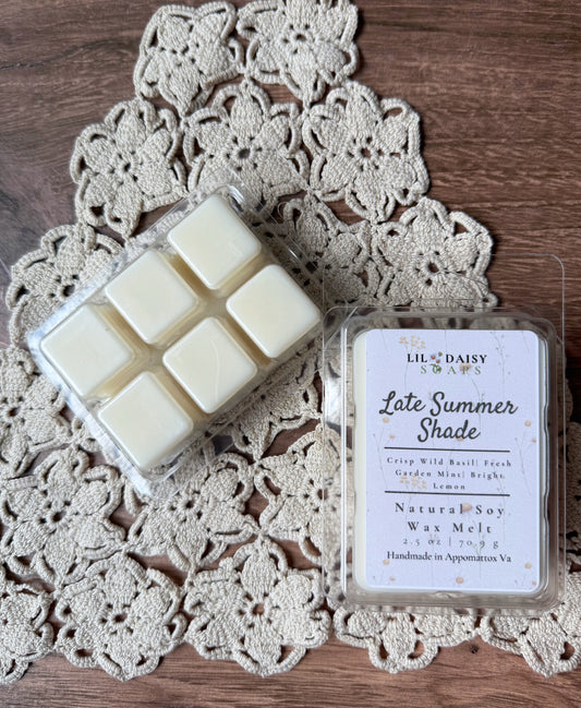 Two Lil Daisy Soaps Late Summer Shade soy wax melts, one open, on a lace doily.