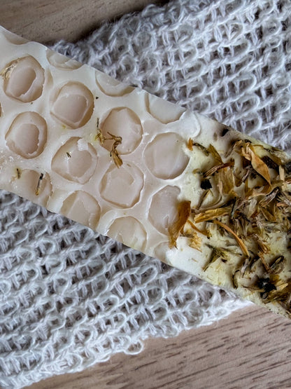 Lil Daisy Soaps Milk & Honey Goat Milk Soap Bar with Skin Soothing Oats on a textured white cloth.