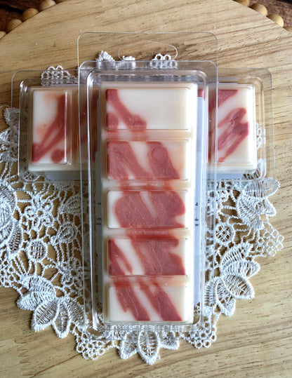 Lil Daisy Soaps Peach Bellini Wax Melt Snap Bars with pink-white marbling on a lace doily and wood.