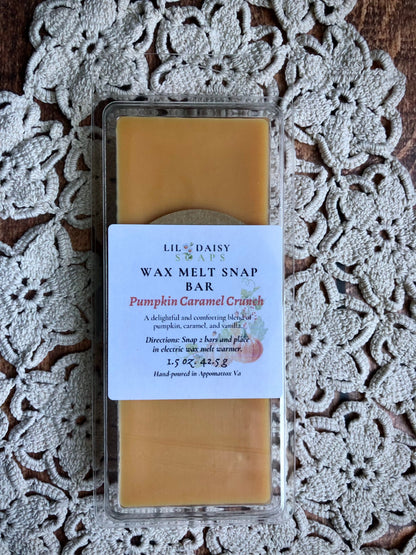A Lil Daisy Soaps Pumpkin Caramel Crunch Snap Bar Wax Melt rests on a crocheted lace surface.