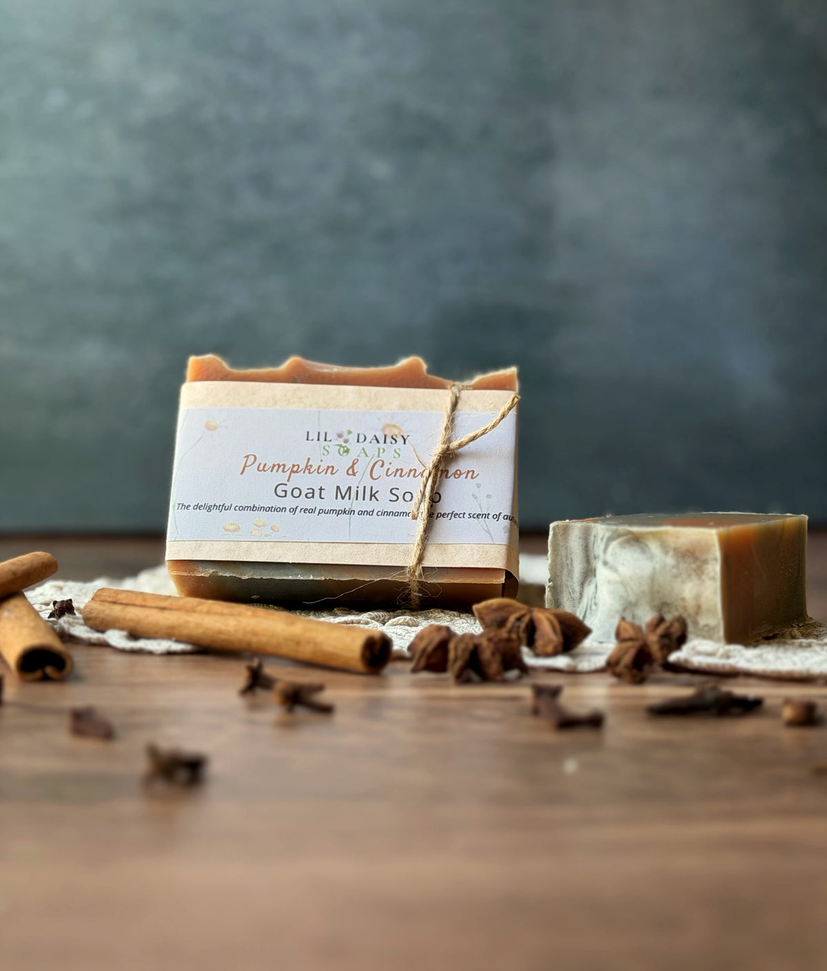 Lil Daisy Soaps Pumpkin Cinnamon Goat Milk Soap bars with cinnamon sticks and star anise on wood table.