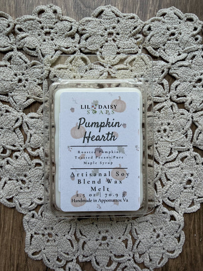 Pumpkin Hearth Wax Melts from Lil Daisy Soaps add cozy autumn charm on a wood background with a crocheted doily.
