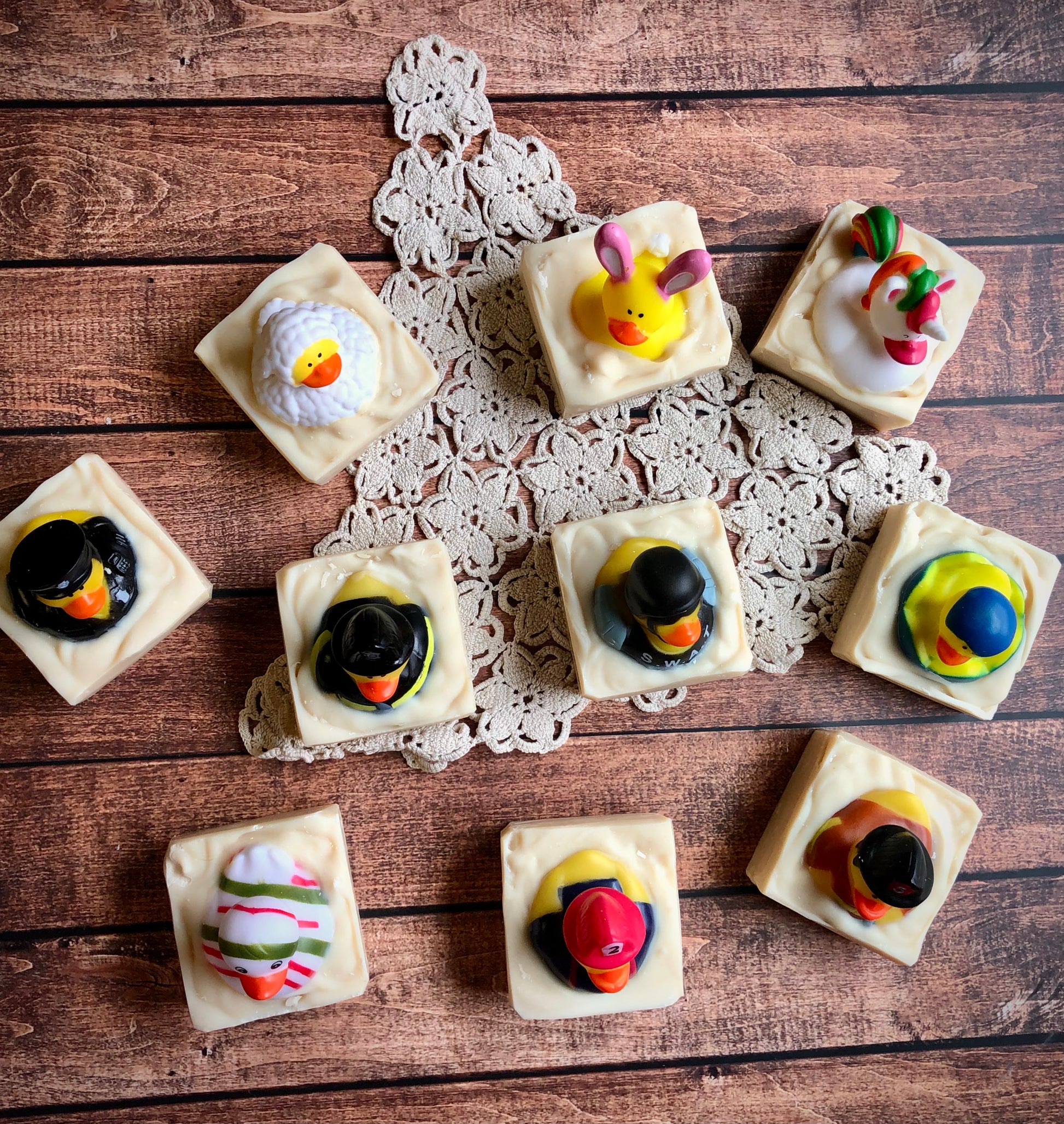 Lil Daisy Soaps Rubber Ducky Goat Milk Soap bars topped with colorful ducks, arranged on a doily.