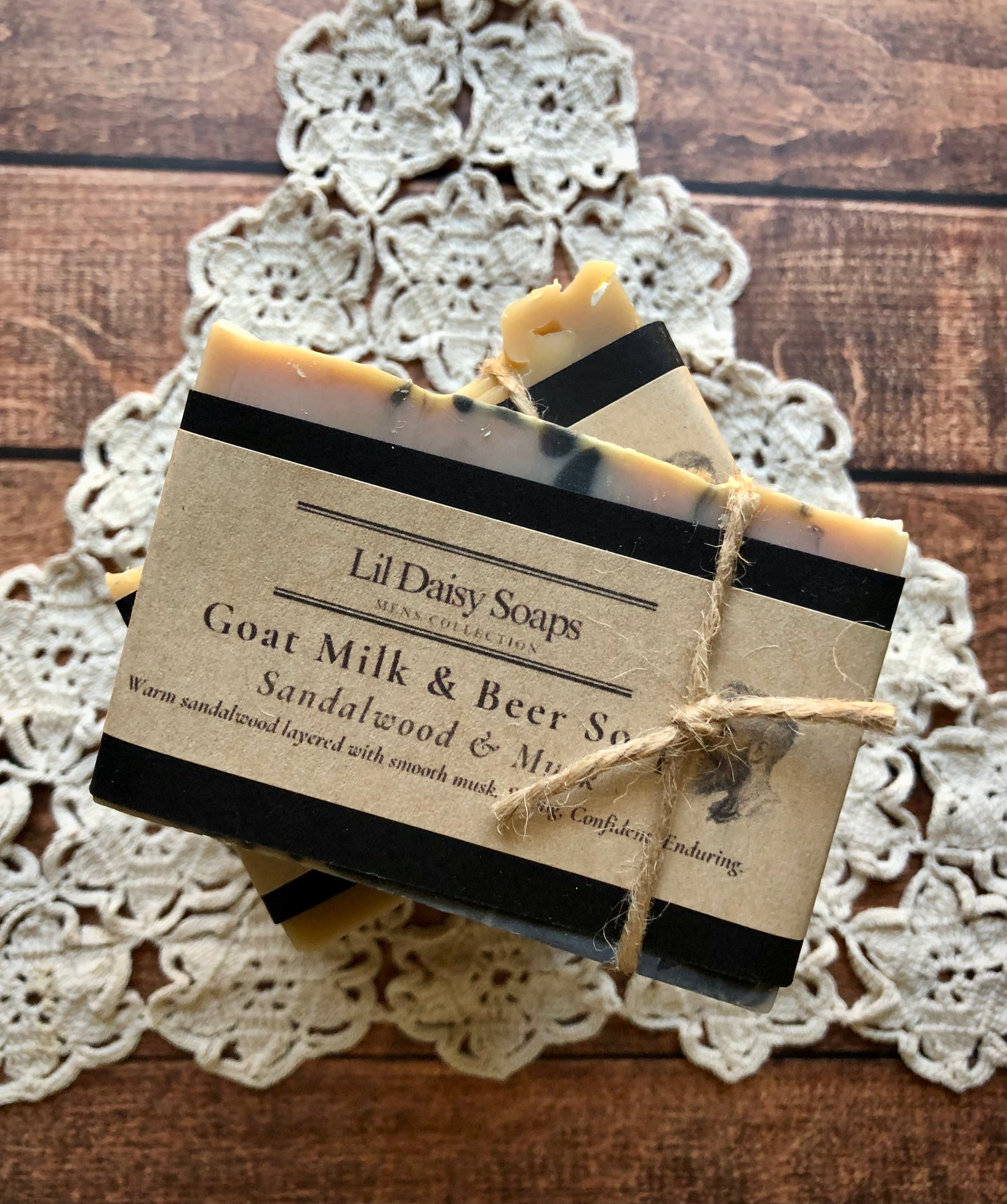 Two Sandalwood & Musk Goat Milk & Beer Soaps by Lil Daisy Soaps, tied with twine on a lace doily.