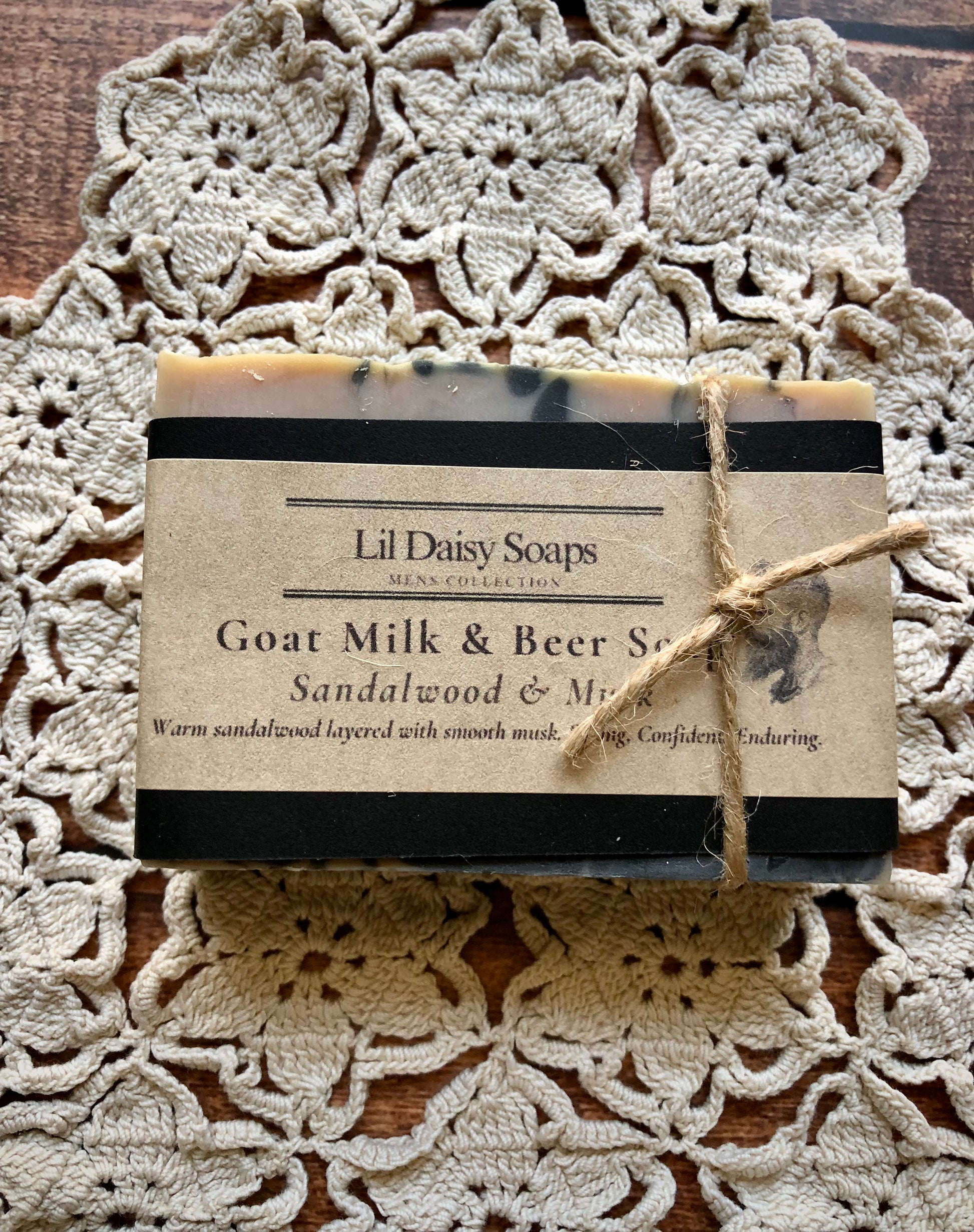 Bar of Lil Daisy Soaps Sandalwood & Musk Goat Milk & Beer Soap, creamy lather, wrapped in brown paper with twine.