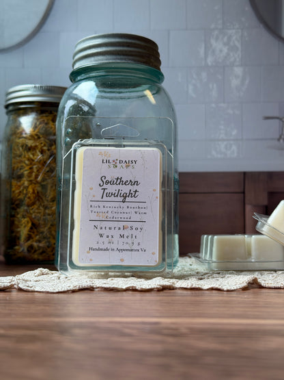 Southern Twilight Soy Wax Melt by Lil Daisy Soaps rests in a jar on a wooden table.