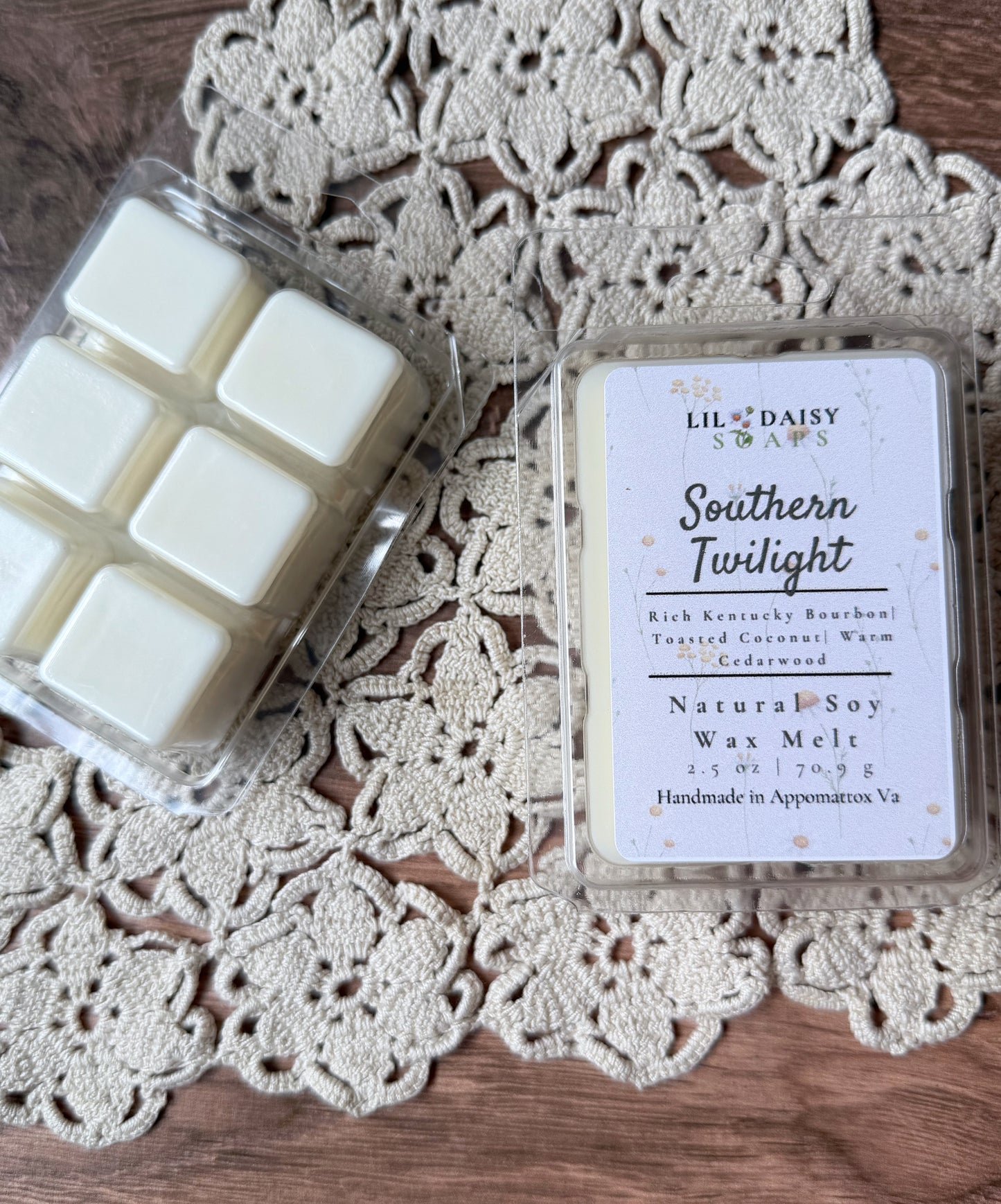 Two Southern Twilight soy wax melts by Lil Daisy Soaps, one open, on a lace doily.