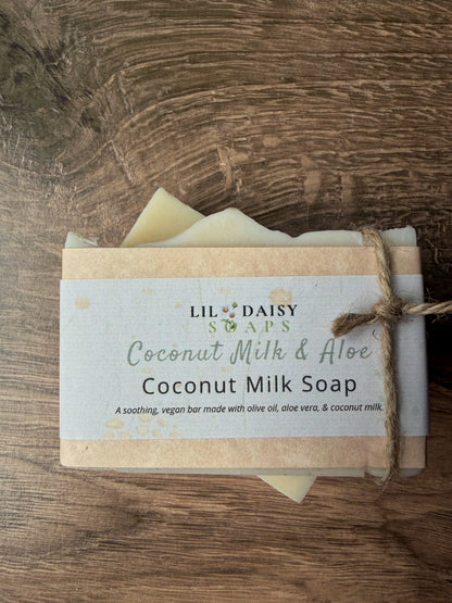 A Lil Daisy Soaps Unscented Coconut Milk & Aloe Soap Bar, wrapped in a label and tied with twine.