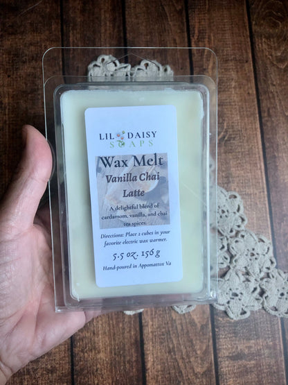 Hand holding a Lil Daisy Soaps Vanilla Chai Latte Snap Bar Wax Melt, made with clean fragrance oils, on lace.