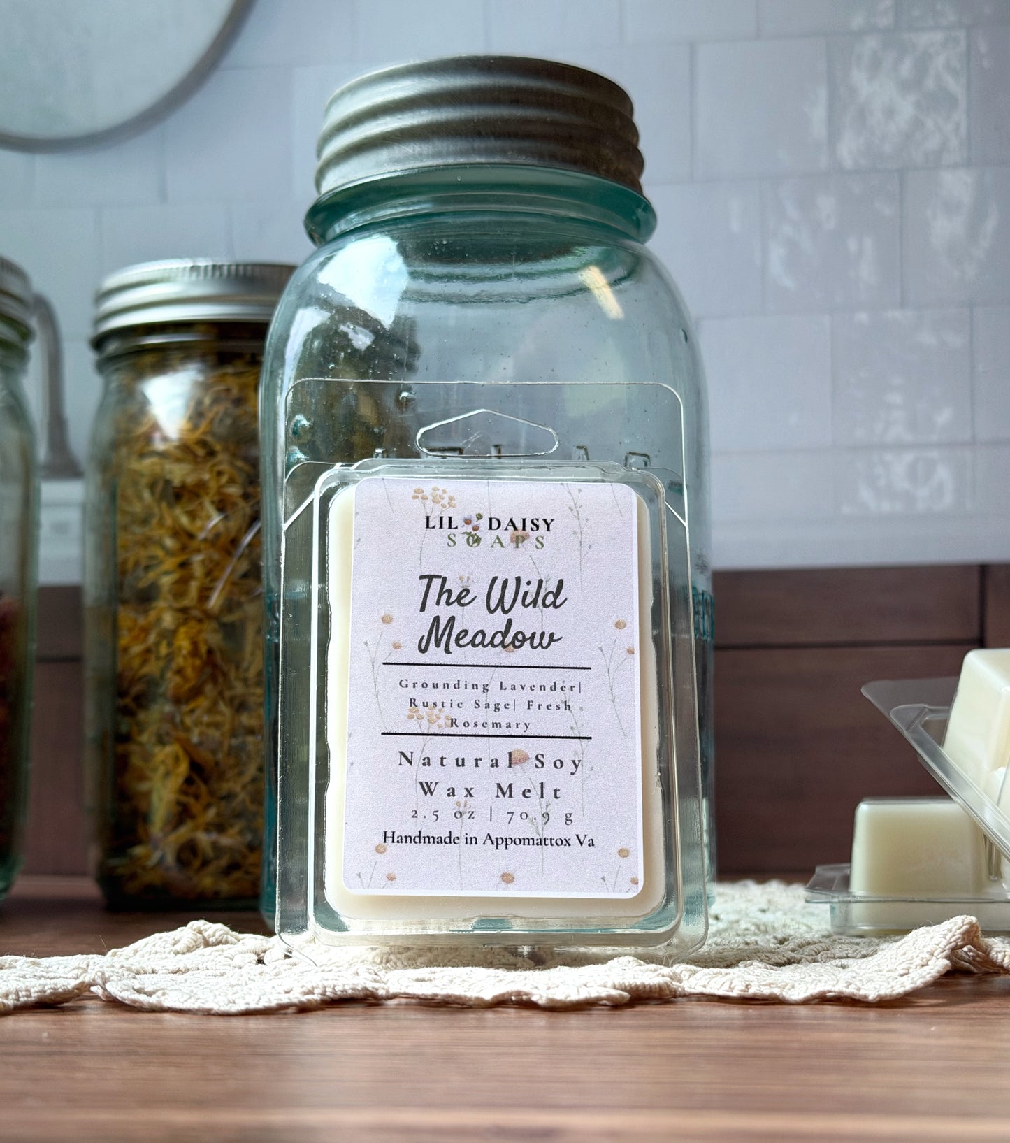 Wild Meadow Soy Wax Melts by Lil Daisy Soaps are shown in front of a vintage blue mason jar.