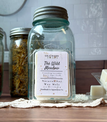 Wild Meadow Soy Wax Melts by Lil Daisy Soaps are shown in front of a vintage blue mason jar.